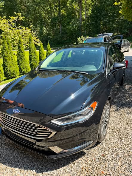 Front end of a black sedan gleaming after a Cleanslate detail