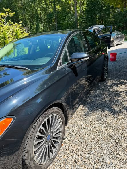 Black sedan gleaming after exterior detailing