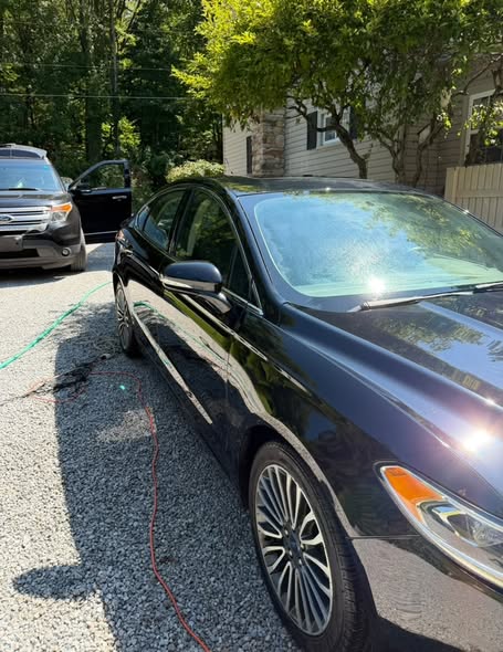 Black sedan side profile after a full detail